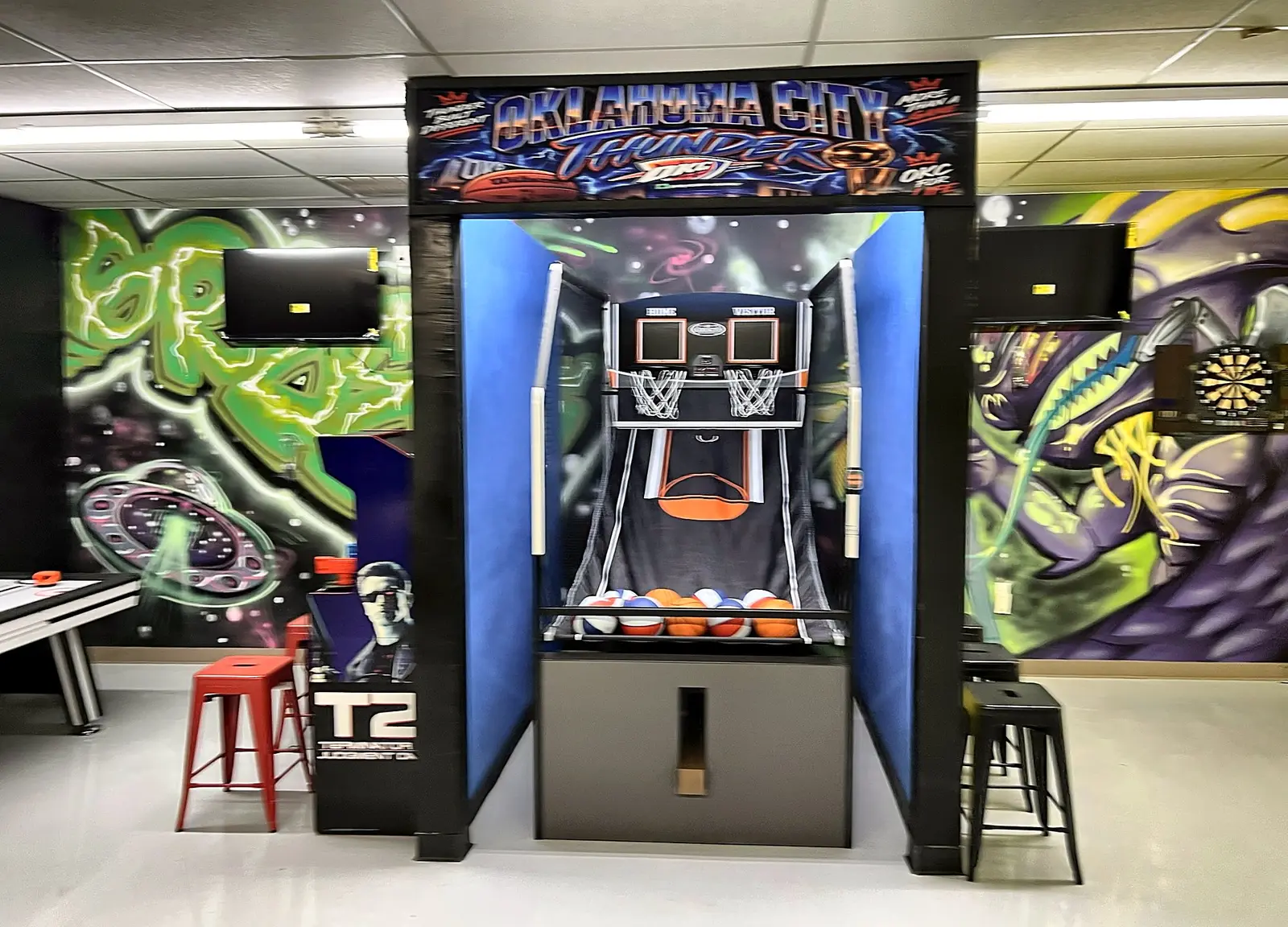 Basketball arcade game under an OKC banner