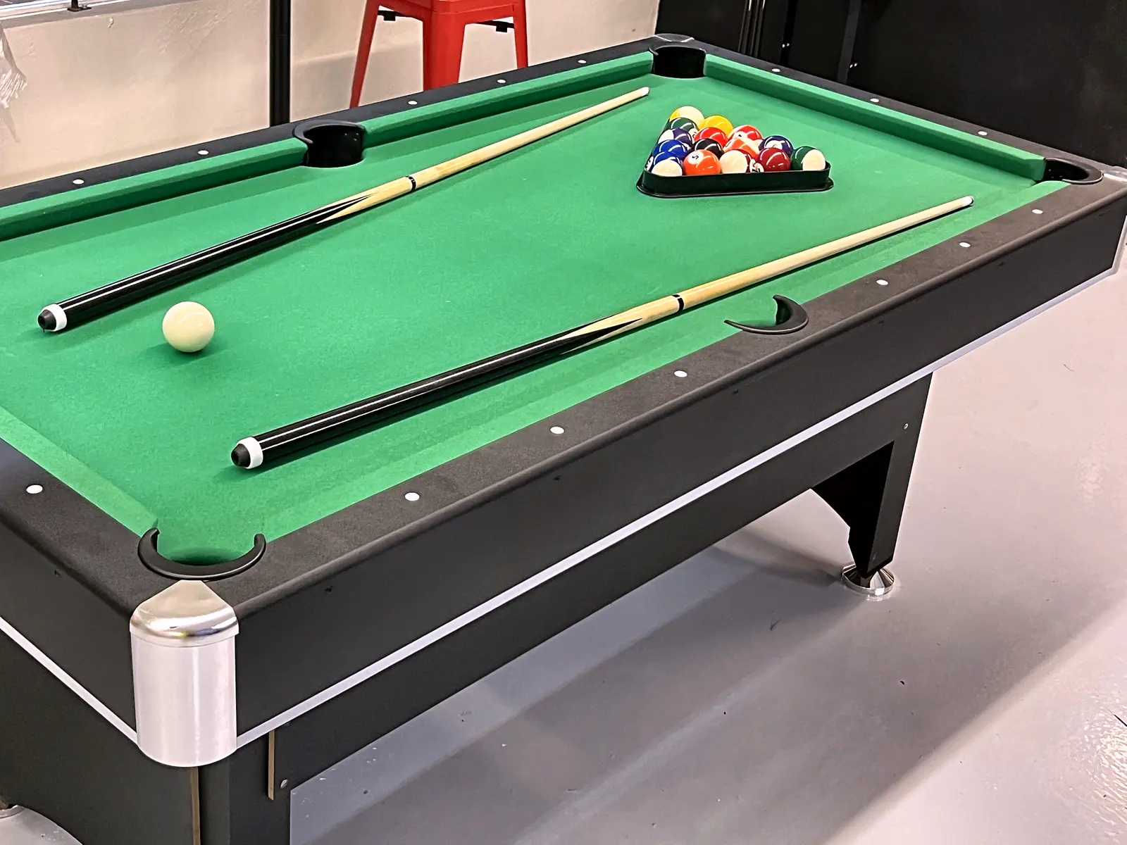 Pool table with cues and a full rack